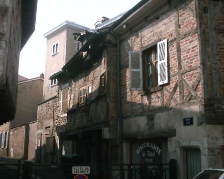A half-timbered brick house jettied over the street